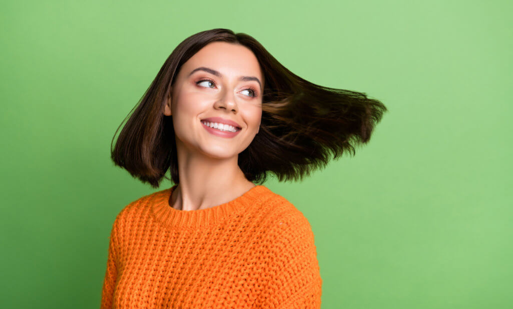 Portrait of attractive cheerful dreamy girl throwing hair enjoying dream isolated over bright green color background