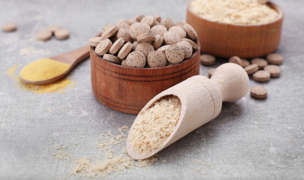 Different types of brewer's yeast on grey table, closeup