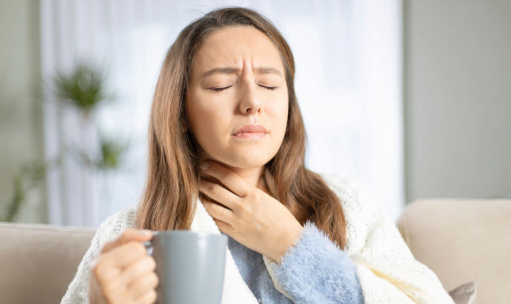 Young woman touching painful neck, sore throat for flu, cold and infection